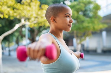 Curvy black woman doing a dumbbell upper-body workout