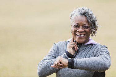 older adult taking pulse during exercise to build muscle over 60