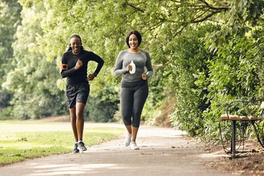 two women running in the park for partner workout