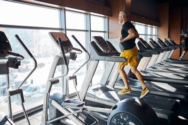 and older adult jogging on a treadmill at a gym