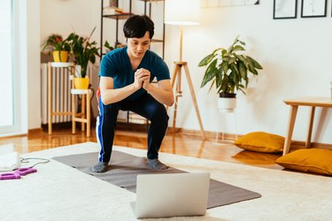 Man performing HIIT workout at home.