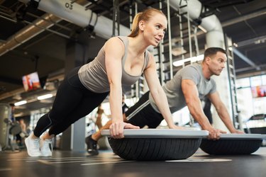 Couple Doing Balance Exercises in a Gym as an example of an exercise that's safe for people with degenerative disc disease