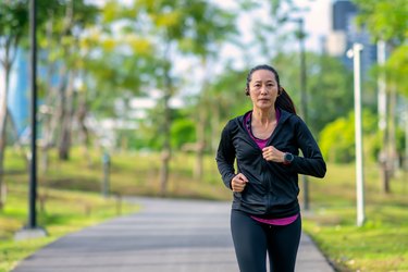 Middle-aged adult running outside to demonstrate exercising during menopause.