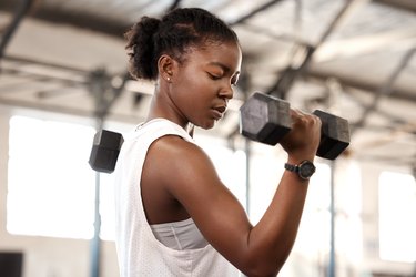 Person doing a biceps curl with a dumbbell in the gym