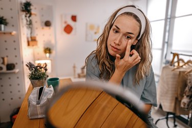 Woman looking at an eye stye in the mirror