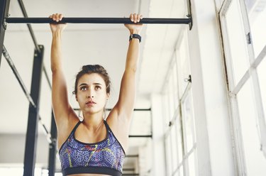 Low angle view of person in gym trying to do a pull-up