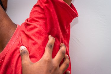 Itching of skin diseases - Man Uses his hand to scratch the armpit for itch skin. Not something to do in outside public places.