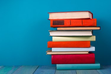 Stack of colorful books, grungy blue background, free copy space