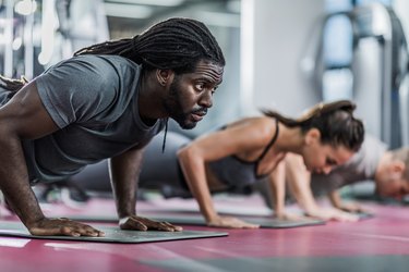 Group of athletes performing push-ups to demonstrate doing an advanced 20-minute body-weight workout