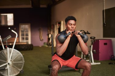 Man in gym using kettle bells