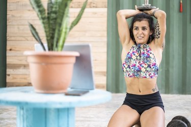 Young woman using tablet during workout at home